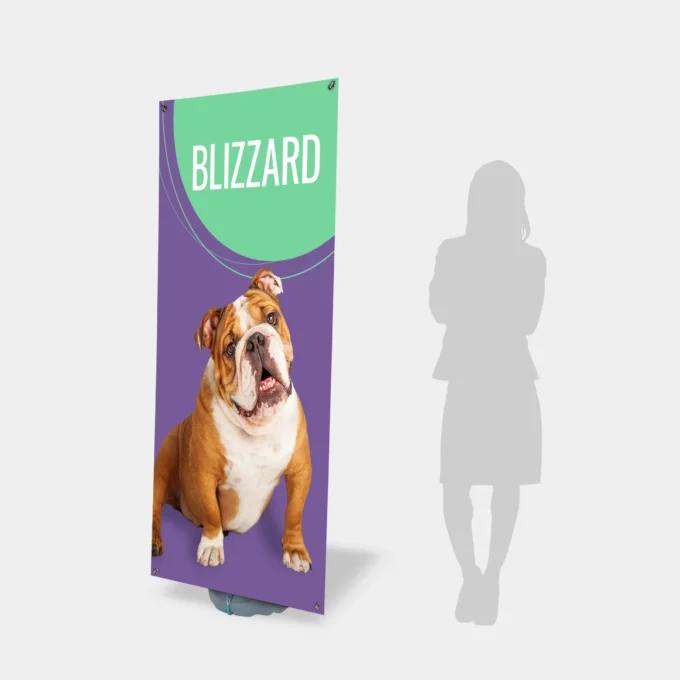 Pionowy rollup z nadrukiem buldoga angielskiego i napisem Blizzard, stojący obok sylwetki osoby jako projektowanie graficzne