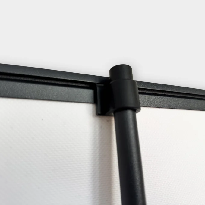 Zbliżenie na czarny uchwyt i górną listwę stelaża, który podtrzymuje reklamowy rollup przygotowany przez naszą agencję marketingową